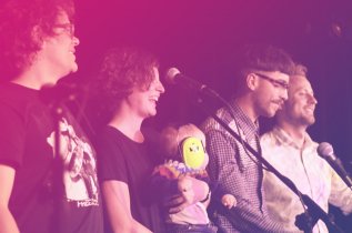 Vier junge Menschen vor Mikrofon; Liederslam im Kulturfenster Heidelberg 